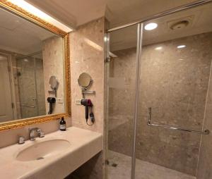 ein Badezimmer mit Waschbecken und Dusche mit Spiegel in der Unterkunft Corner Inn in Taichung