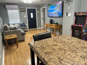 a living room with a table and a video game at Pool house , near downtown SA in San Antonio