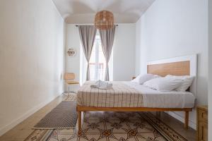 a bedroom with a bed and a large window at BISCOTTAI Port Apartments in Trapani