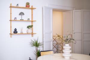 a dining room with a table and shelves at BISCOTTAI Port Apartments in Trapani +53 photos