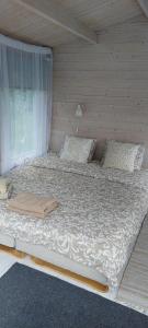 a large bed in a room with a wooden wall at Jaagu majad in Suuremõisa