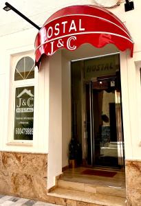 a restaurant with a red awning over the door at Hostal J&C in Olula del Río