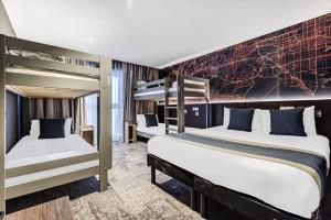 zwei Betten in einem Zimmer mit zwei Etagenbetten in der Unterkunft Heeton Concept Hotel – Luma Hammersmith in London