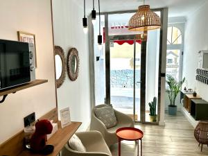 a living room with a tv and chairs and a table at Hostal J&C in Olula del Río