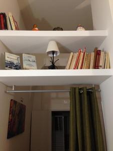 uno scaffale con libri, lampada e tenda di Casa Normanna a Salerno