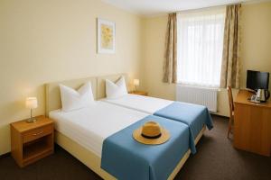 a hotel room with a bed with a hat on it at Nad brzegiem Bałtyku in Sarbinowo