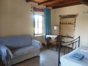 a living room with a couch and a table and a window at BeB LORTALLINO in Ameno