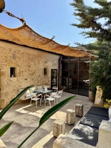 a patio with a table and chairs next to a building at Domaine de Ribaute in Lieuran-lès-Béziers