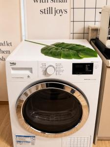 a washing machine with a green leaf on top at 수원 화서역 편한 집 in Suwon