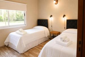 two beds in a room with a window at Olivos de Monte in San Miguel del Monte