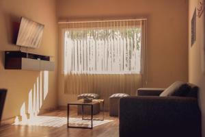 a living room with a couch and a large window at Olivos de Monte in San Miguel del Monte