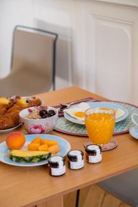 a table with plates of food and a bowl of fruit at L'Hôtel Particulier Beziers in Béziers