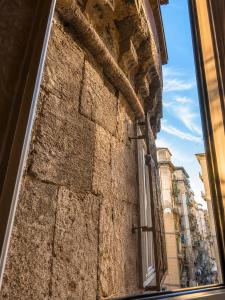 a window in a stone building with a view of a street at RELAIS TORRE GLORIA in Naples