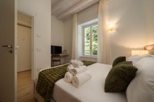 a bedroom with a bed with towels on it at Flowers Liberty Suites in Brescia