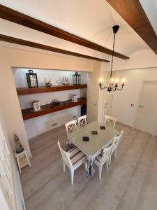 a dining room with a white table and chairs at Villa Wilecris in Punta Umbría