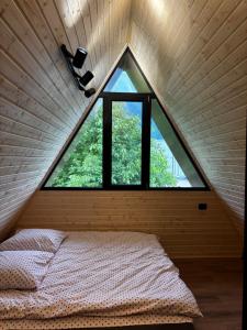 a bed in a room with a large window at kesis chalet in Borjomi