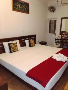 a large bed with a red and white blanket on it at Rio Lake Hotel Sigiriya in Habarana +58 photos