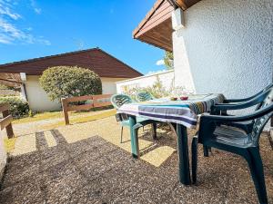 a table and two chairs sitting next to a building at Location appartement plain pied T3 à 8 KMS de l'océan in Lit-et-Mixe