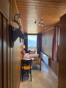 ein Zimmer mit einem Tisch und ein Zimmer mit einem Schlafzimmer in der Unterkunft Hotel Fassbind Beausite in Beatenberg