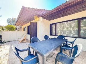 a blue table and chairs on a patio at Location appartement plain pied T3 à 8 KMS de l'océan in Lit-et-Mixe
