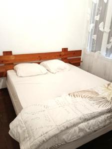 a bedroom with a bed with a wooden headboard at Location appartement plain pied T3 à 8 KMS de l'océan in Lit-et-Mixe