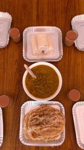 a table with a bowl of soup and a plate of bread at Idanazhi the corridor in Kozhikode +10 photos