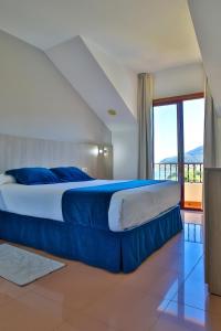 a bedroom with a large bed and a large window at Hotel Restaurante Glasgow in Villadesuso +32 photos