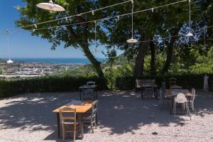 a group of tables and chairs under a tree at Villa da Angelo by Mmega in Aquaviva Picena