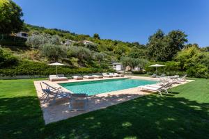 a swimming pool with chairs and umbrellas in a yard at Villa da Angelo by Mmega in Aquaviva Picena