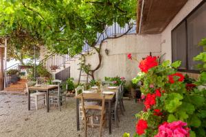 a patio with tables and chairs and red flowers at Villa da Angelo by Mmega in Aquaviva Picena