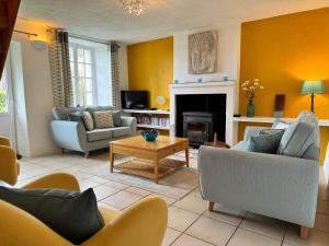 a living room with couches and a fireplace at Walnut Tree Gîte in Boderel