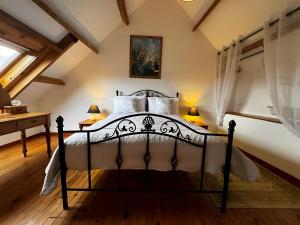 a bedroom with a black and white bed at Walnut Tree Gîte in Boderel +37 photos