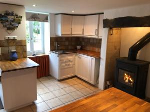 a kitchen with a stove in the middle of it at Walnut Tree Gîte in Boderel