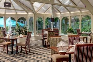 a restaurant with tables and chairs and windows at B/W Plus Buxton Lee Wood Hotel in Buxton