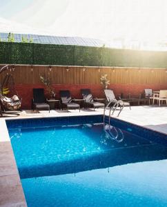 a swimming pool with chairs and a swing at Hotel Boutique Adam in Tbilisi City