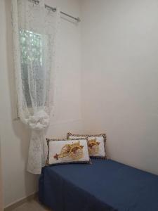 a bedroom with a blue bed and a window at Costa Marina in Marsala