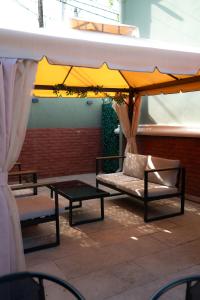 a patio with a couch under a large umbrella at Hotel Boutique Adam in Tbilisi City