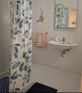 a bathroom with a sink and a shower curtain at Costa Marina in Marsala