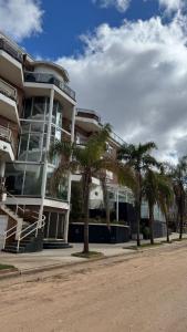 a building with palm trees in front of it at Apart Hotel Punta Vip in Colón