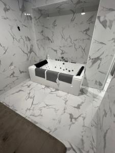 a bathroom with a bath tub on a marble wall at Gandía Jacuzzi Suites in Gandía