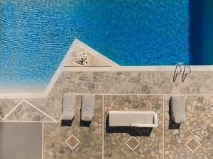 an overhead view of a pool with chairs and water at Mr and Mrs White Tinos in Tinos