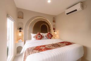 a bedroom with a large white bed with a large window at Maroko Jogja Villas With Privatepool in Ngaglik +63 photos