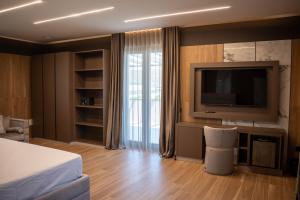 a hotel room with a television and a bed at Tre Fontane Country House in Sperlonga +58 photos