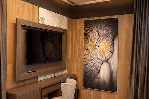 a bathroom with a tv and a wall at Tre Fontane Country House in Sperlonga