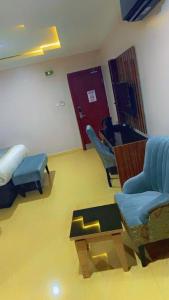 a room with a hospital room with a bed and chairs at Grand East Hotel in Akwa