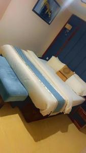 a bed in a room with a blue wall at Grand East Hotel in Akwa