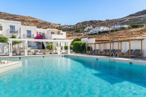 a swimming pool with blue water in front of white buildings at Mr and Mrs White Tinos in Tinos