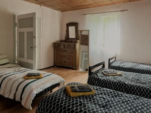 a bedroom with two beds and a dresser and a mirror at Viesu nams Kātiņi in Energetikis