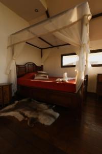 a bedroom with a bed with red sheets and a window at Paraíso Nimah in Flores +22 photos