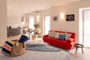 a living room with a red couch and a kitchen at Casa Quadrifoglio - Valgrande in Intra